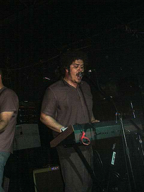 the late richard swift singling while playing a synthesizer.